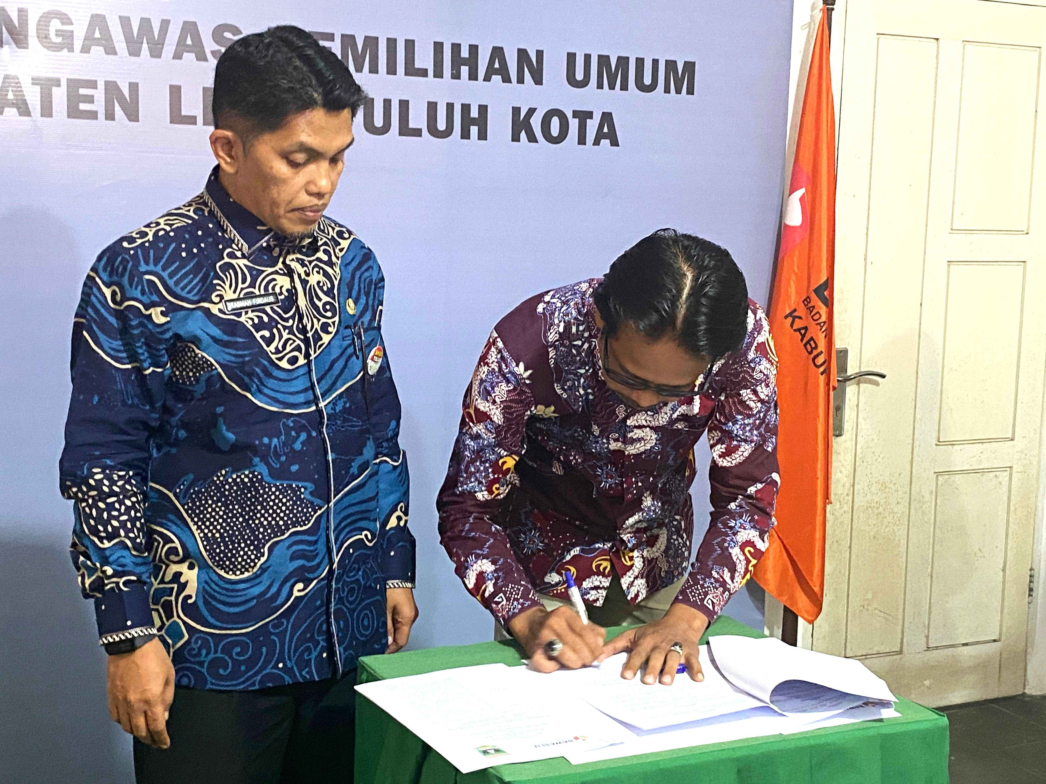 Ketua Bawaslu Lima Puluh Kota bersama Kacabdin Wil. IVmenandatangani MoU