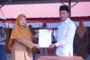 Dapit Alexsander selaku Anggota Bawaslu Kabupaten Lima Puluh Kota saat menyerahkan berkas Perjanjian Kerja Sama (PKS) kepada Kepala Sekolah SMA N 1 Situjuah Limo Nagari Kabupaten Lima Puluh Kota, Fita Fatimah, (31/8).